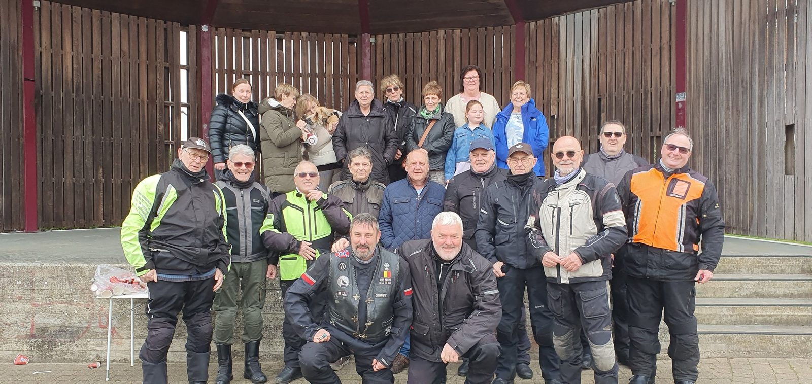 Dezelfde groep, een tweede groepsfoto aan het houten podium.